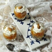 Qubani ka meetha in three shot glasses with cream.