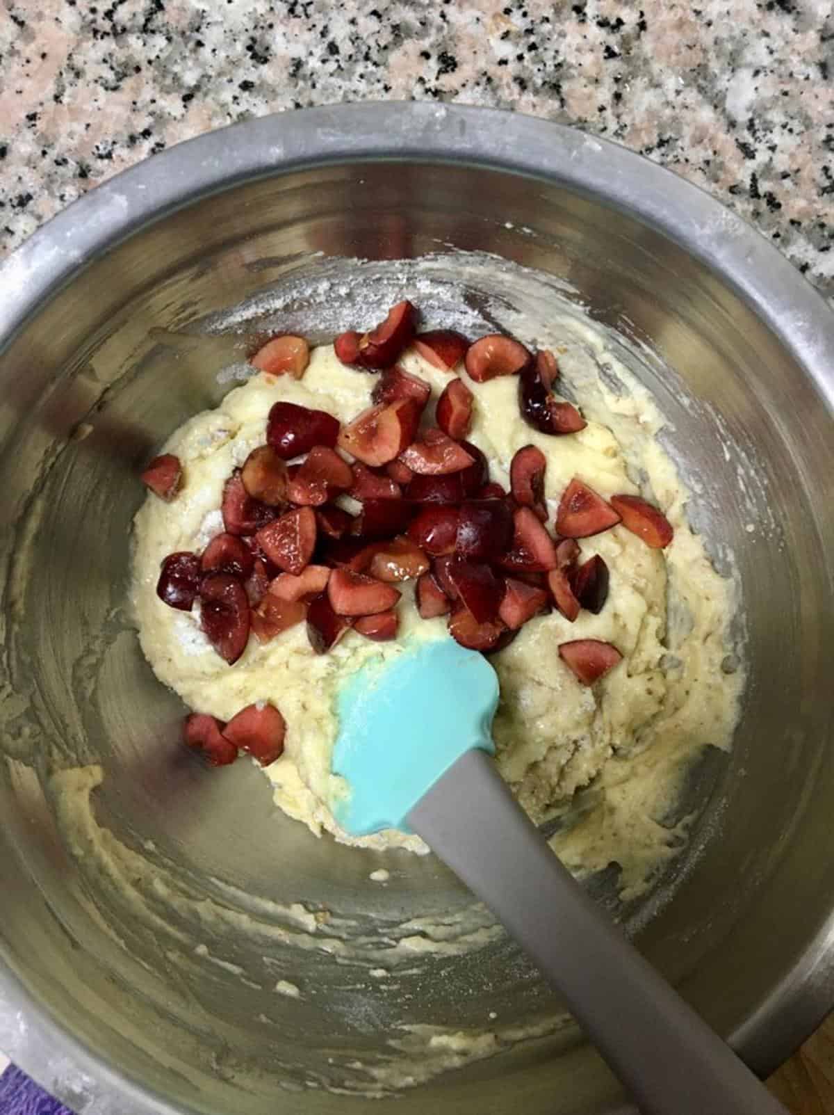 Fresh cherry loaf cake preparation in a mixing bowl for a delicious homemade dessert.