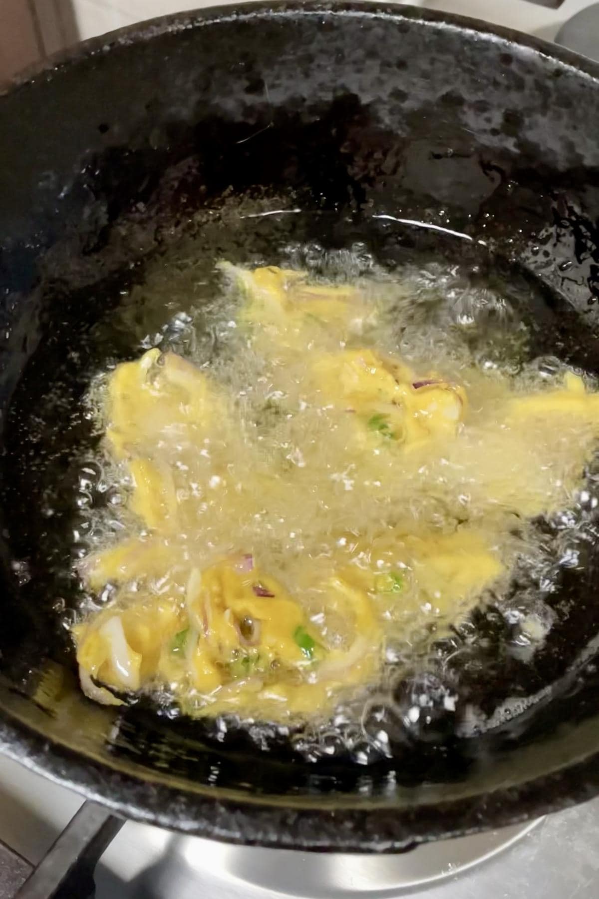 deep frying onion pakoda in batches.