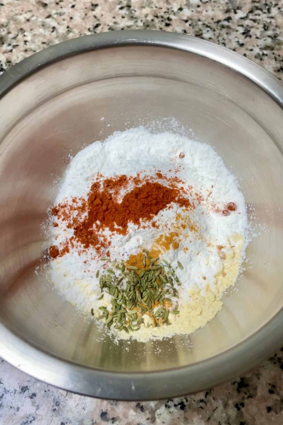 A medium bowl with flour and spices.