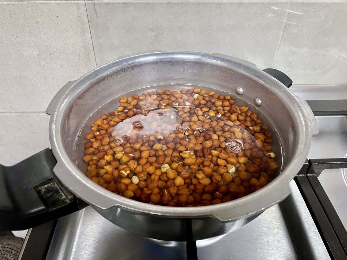 black chickpeas with water in a pressure cooker pan. 