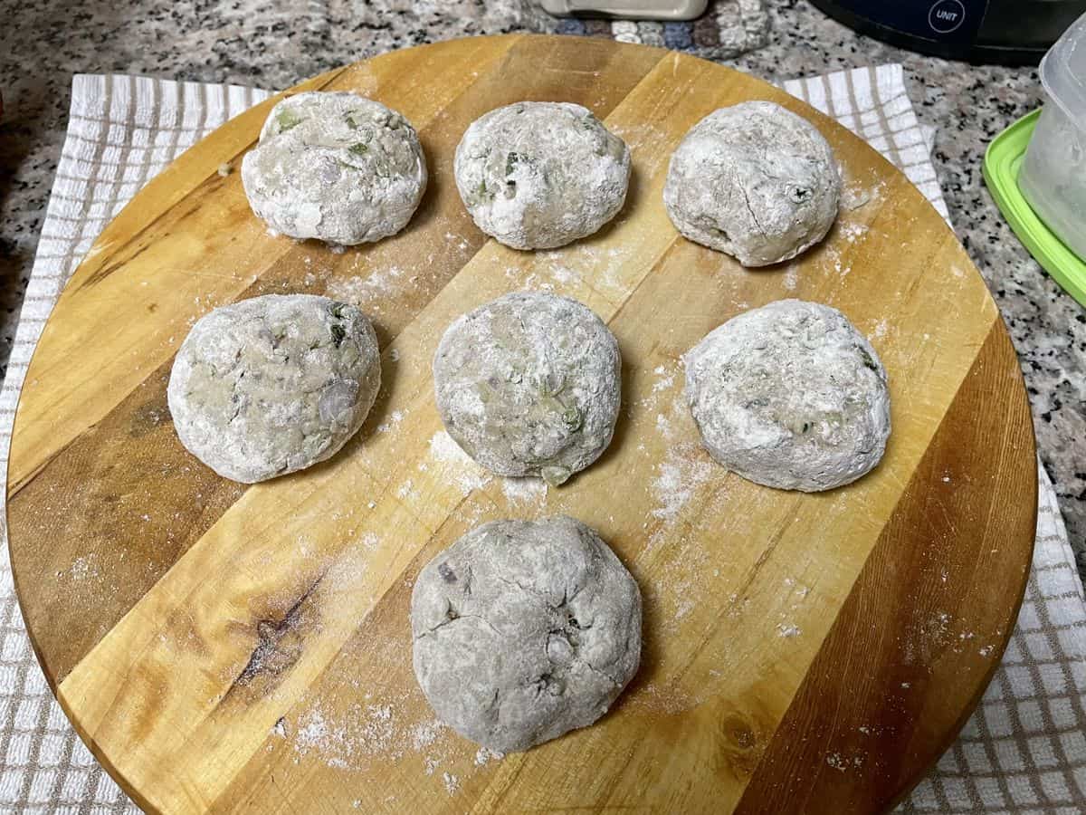 Lauki paratha dough balls smoothened and dusted with flour. 