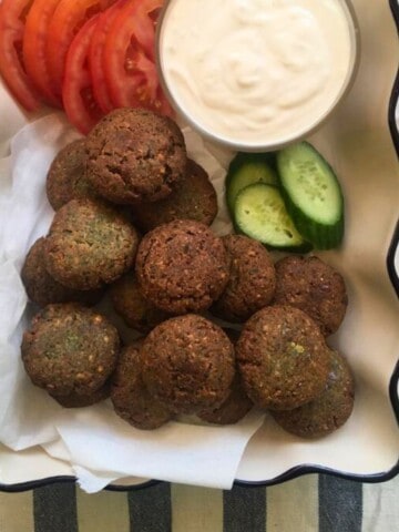 Lebanese falafel patties served with yoghurt dip and tomato slices.