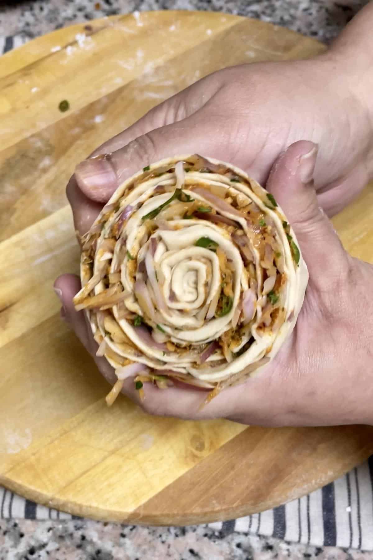 Lachha shaping of onion filled dough.