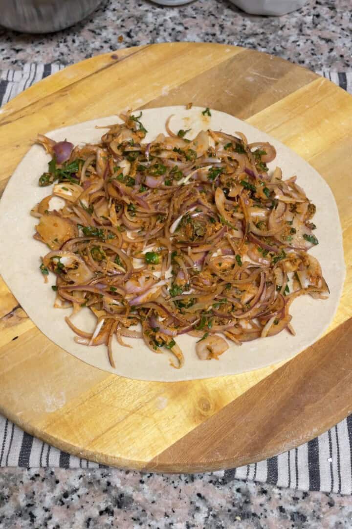Some onion filling spread over a rolled out dough.