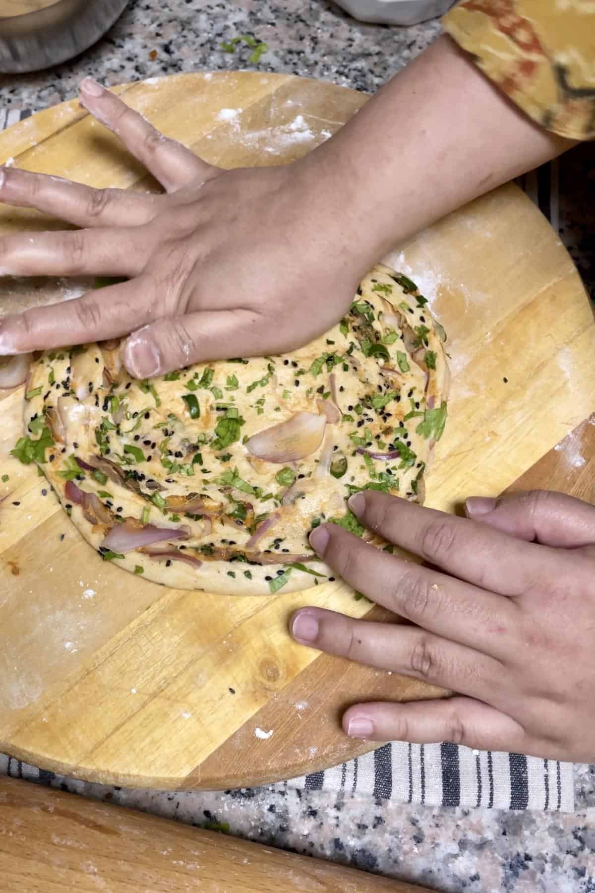 Spreading the stuffed dough using heel of your hand. 