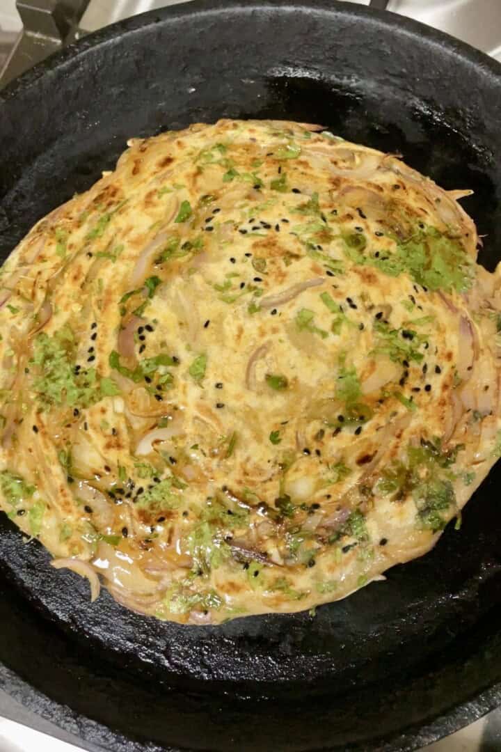 Onion paratha on hot tawa with ghee spread on it