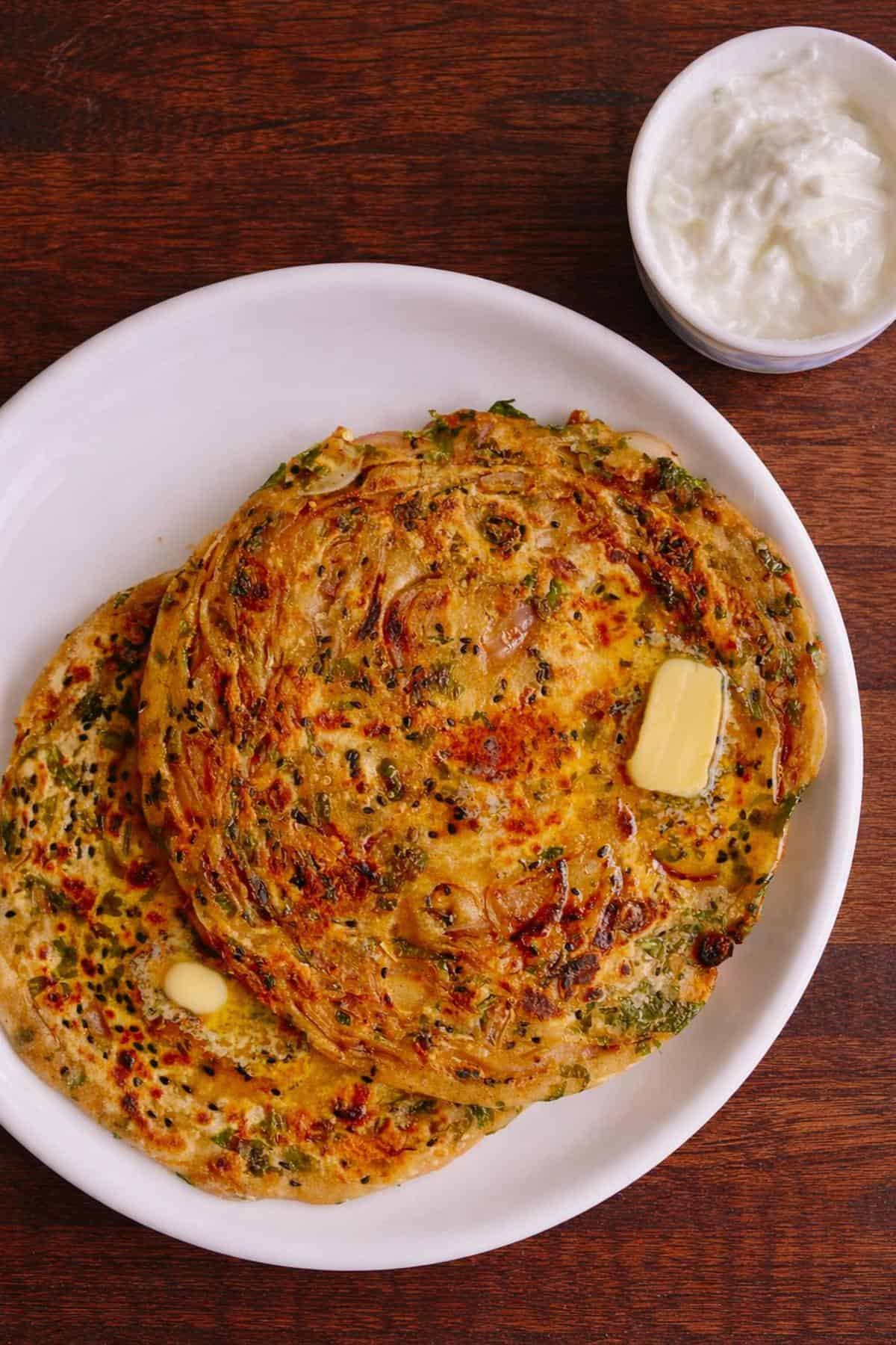 Two onion paratha with a knob of butter and yoghurt bowl. 