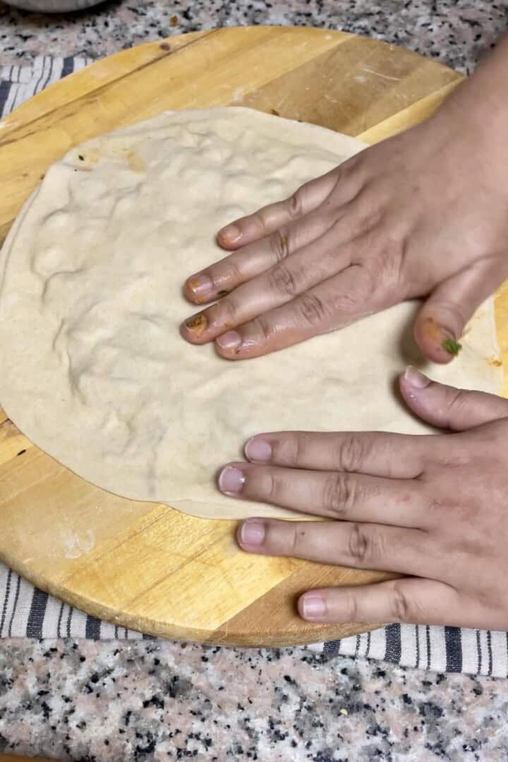 Seal the onion filling with another rolled out dough and press.