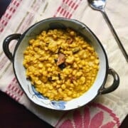 A bowl of cholar dal with a spoon.