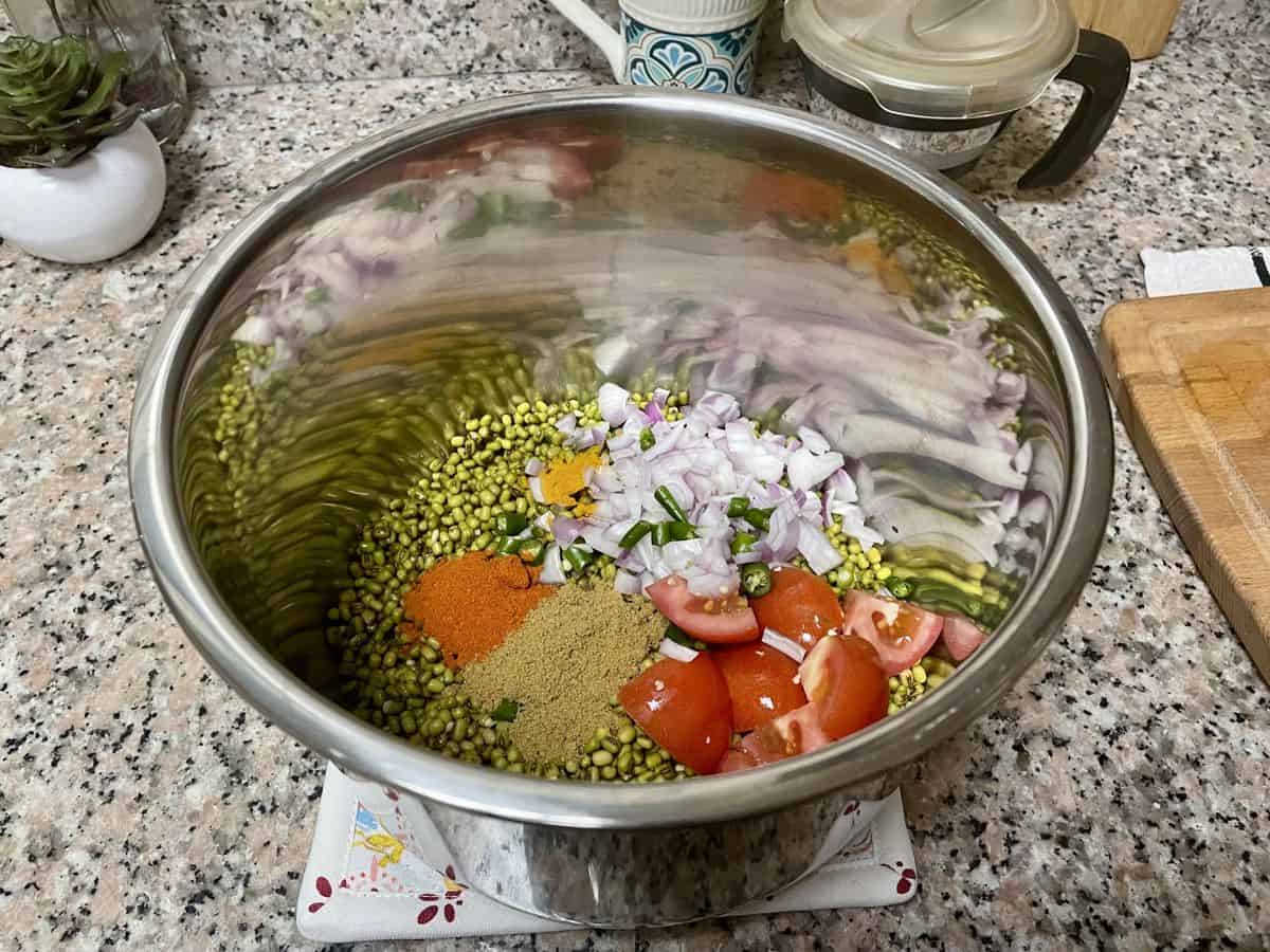 Cherupayar curry ingredients in a pressure cooker pot. 