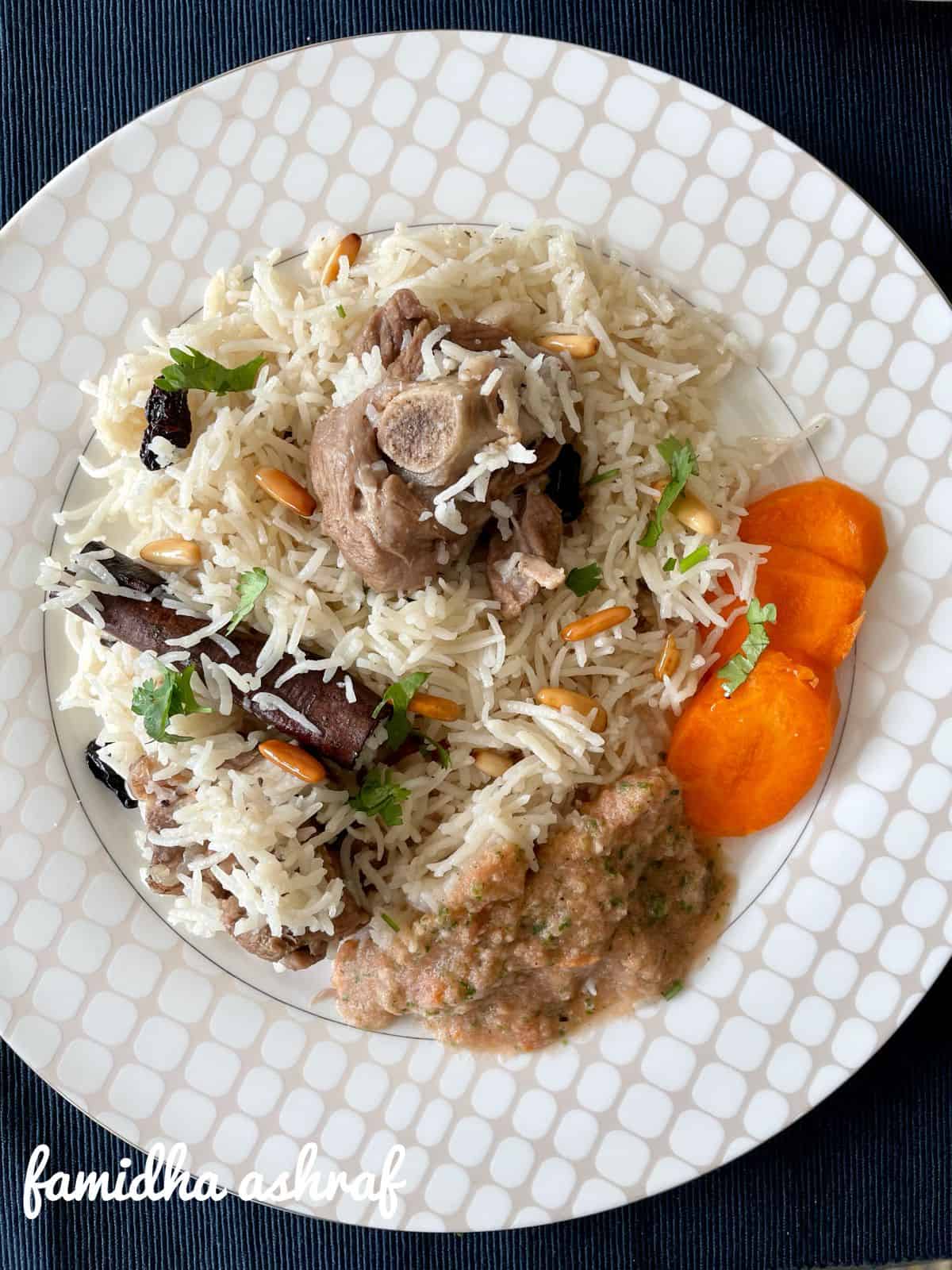 a plate of bedouin lamb rice with salata and carrot slices