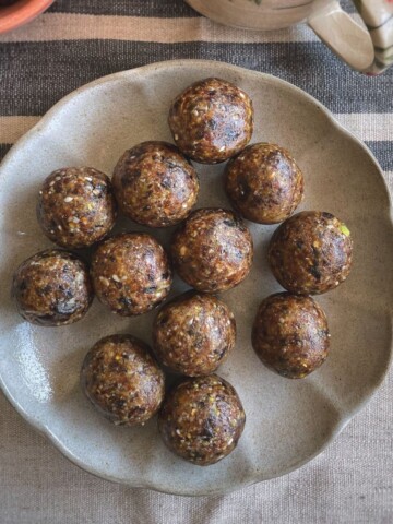 A plate of bliss energy balls with dates and nuts.