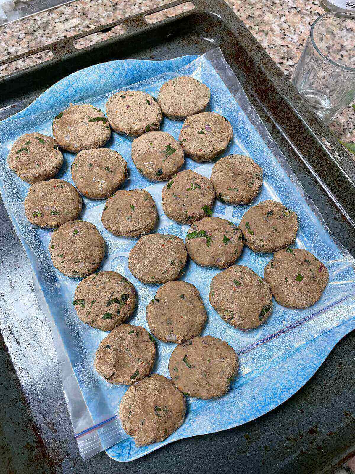 shaped shami kebabs placed in a tray to freeze