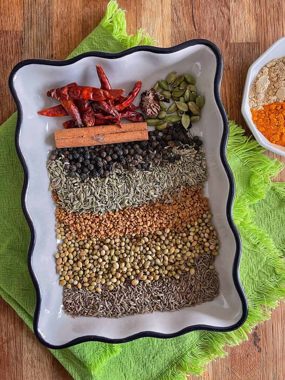 An array of whole spices to make bezar spice blend.