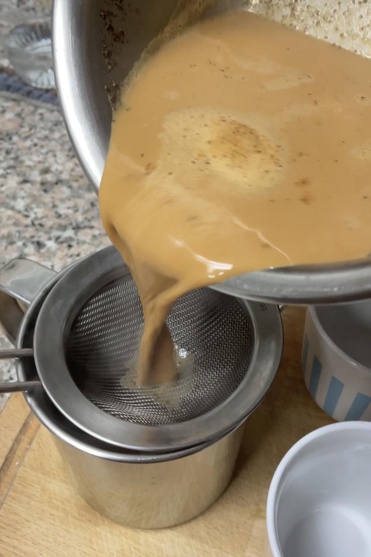 Straining the chai into a serving pot.