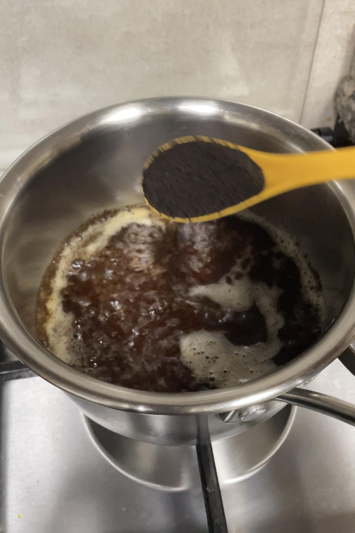 Adding black loose tea leaves to boiling water