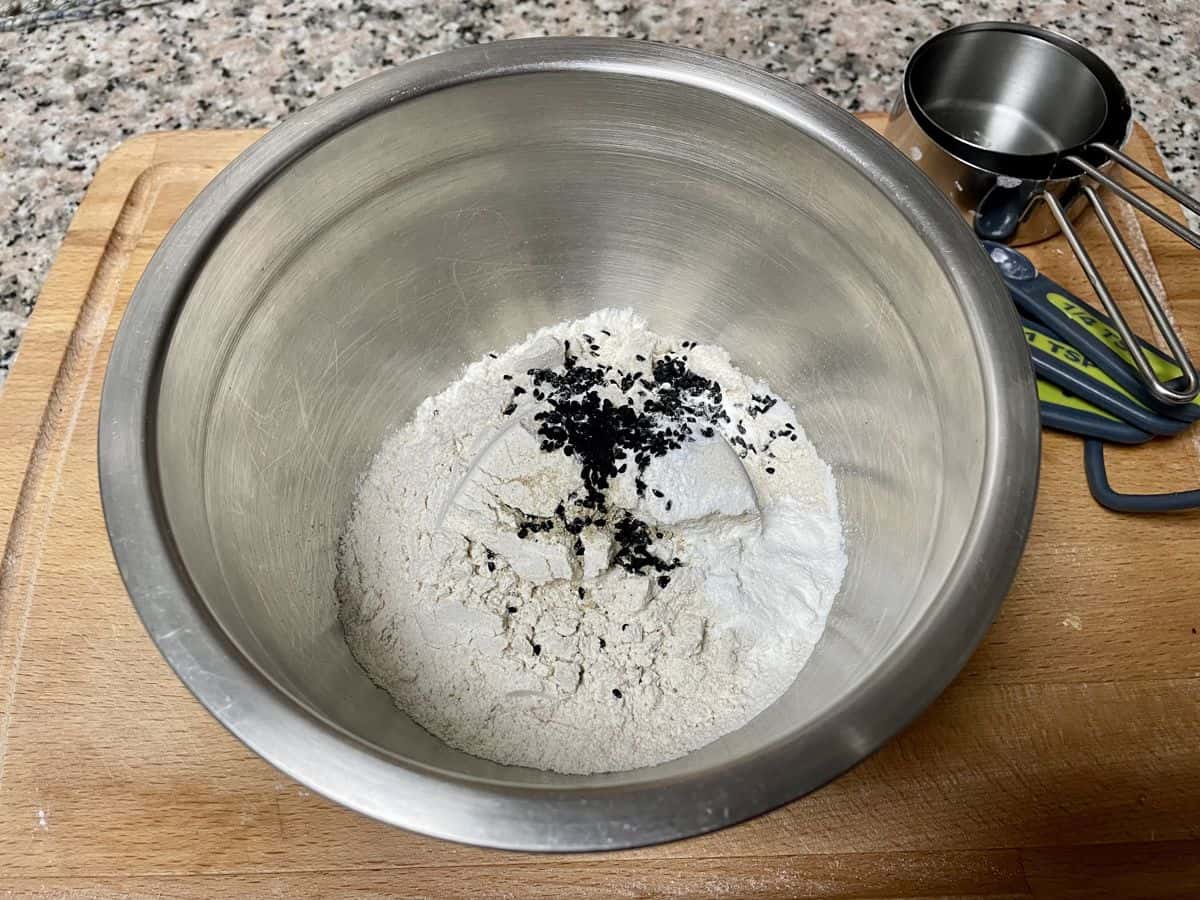 A bowl with flour and nigella seeds.