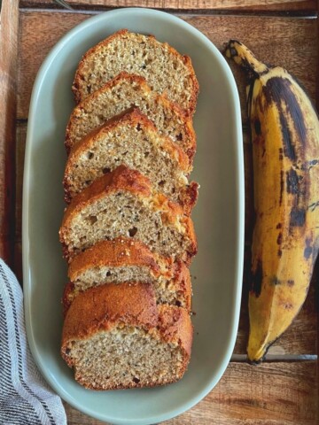 Plantain bread loaf sliced and placed on a plate.
