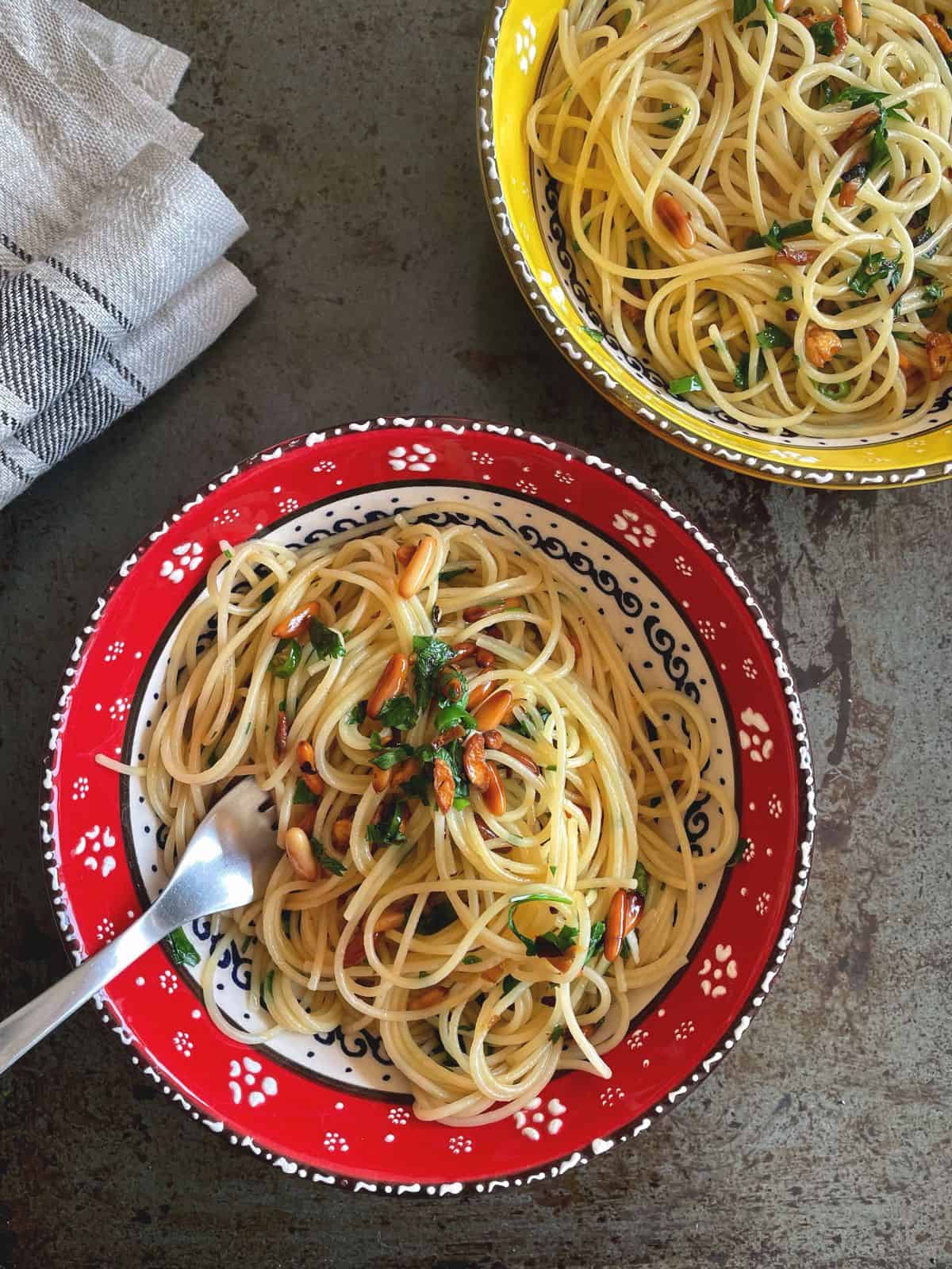 Two bowls of spaghetti aglio e olio. 