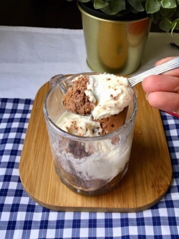 A spoon-scooped bourbon biscuit cheesecake jar.