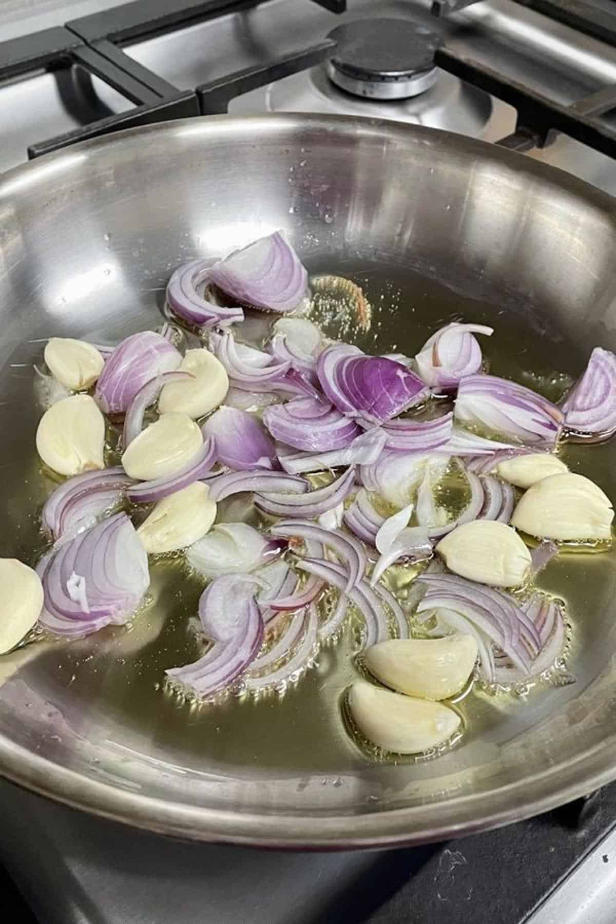 Sliced onions and garlic cloves in oil.