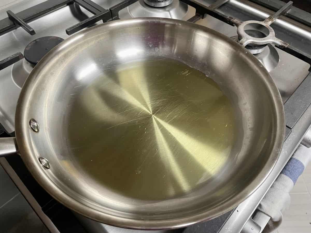 A stainless steel skillet with olive oil.