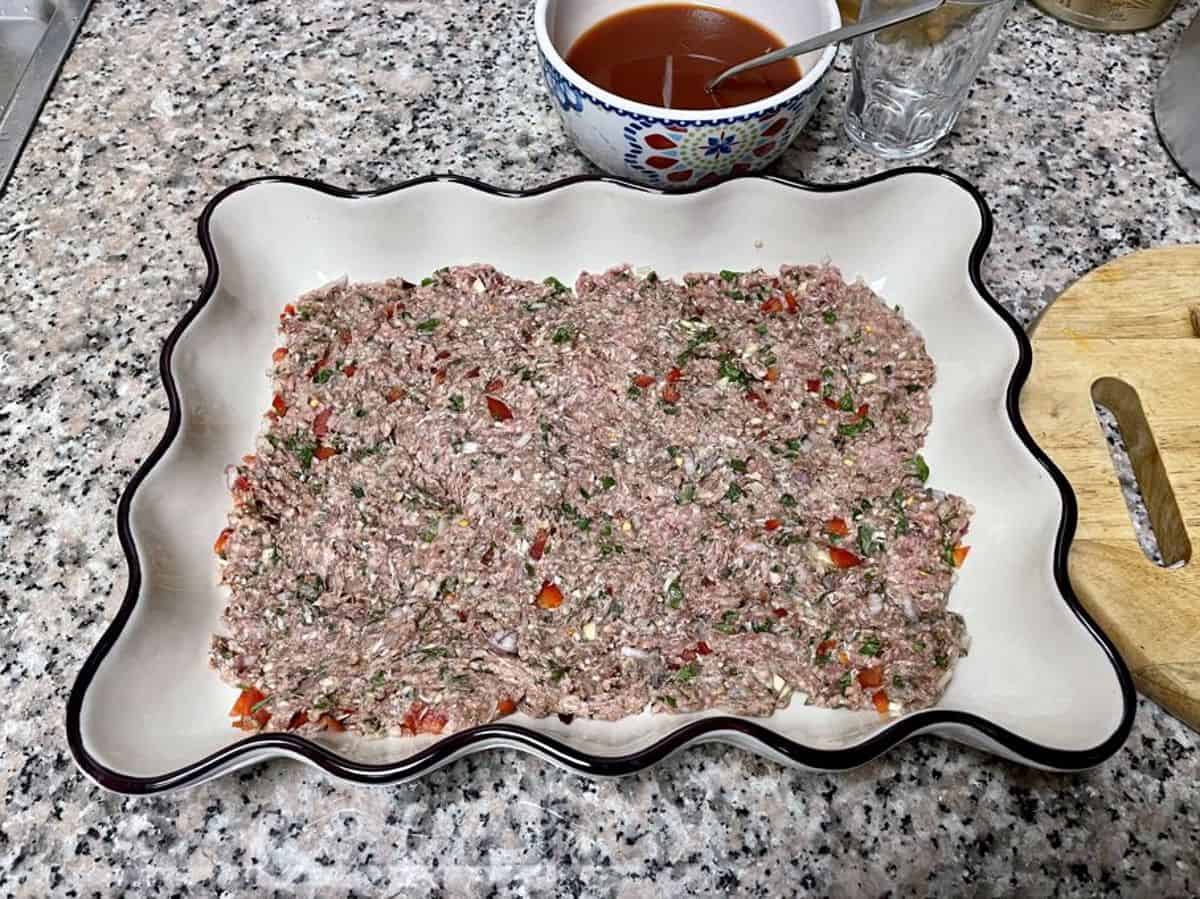 kafta layered in an oven proof casserole dish