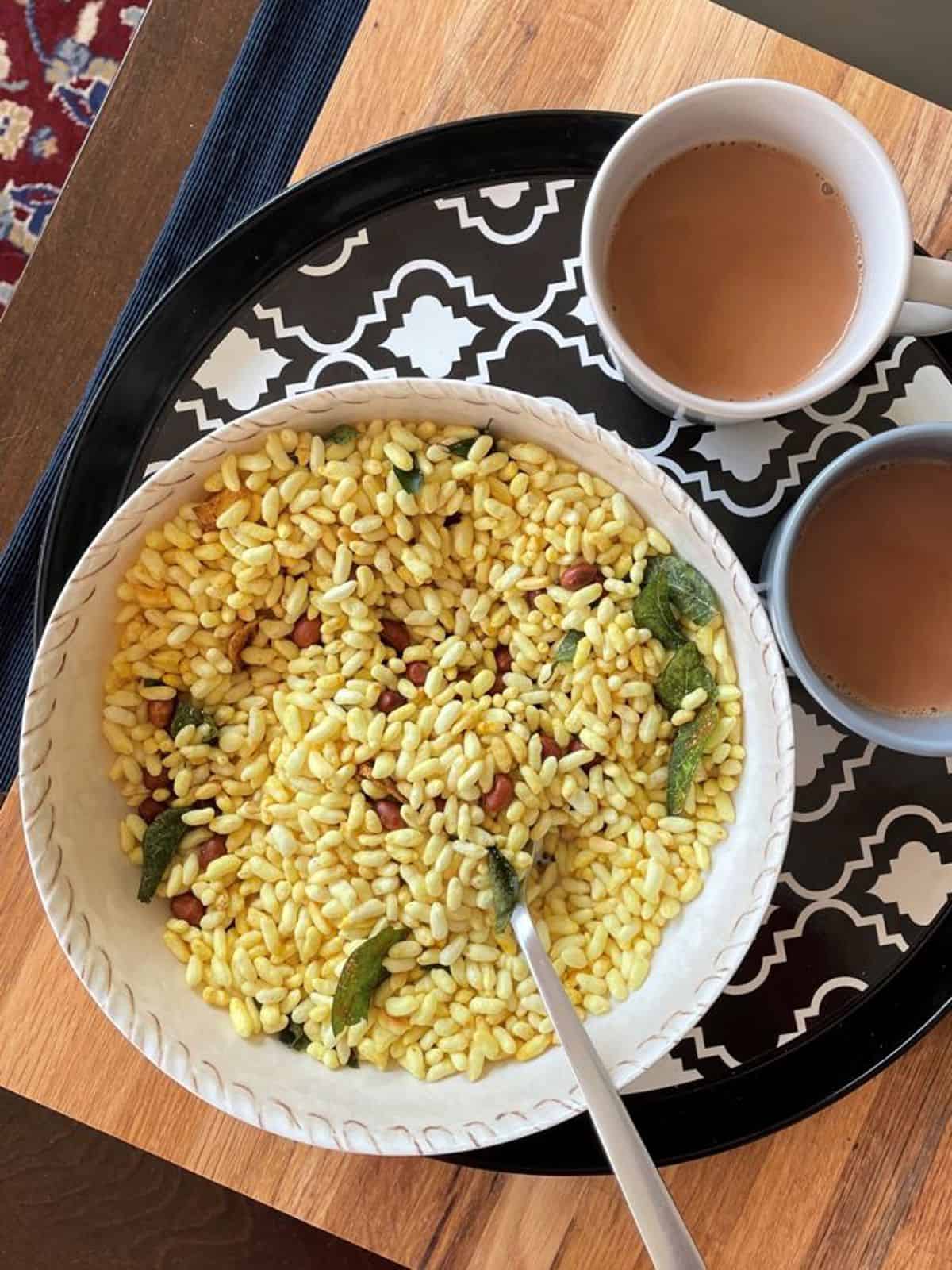 a bowl of kara pori with two cups of chai