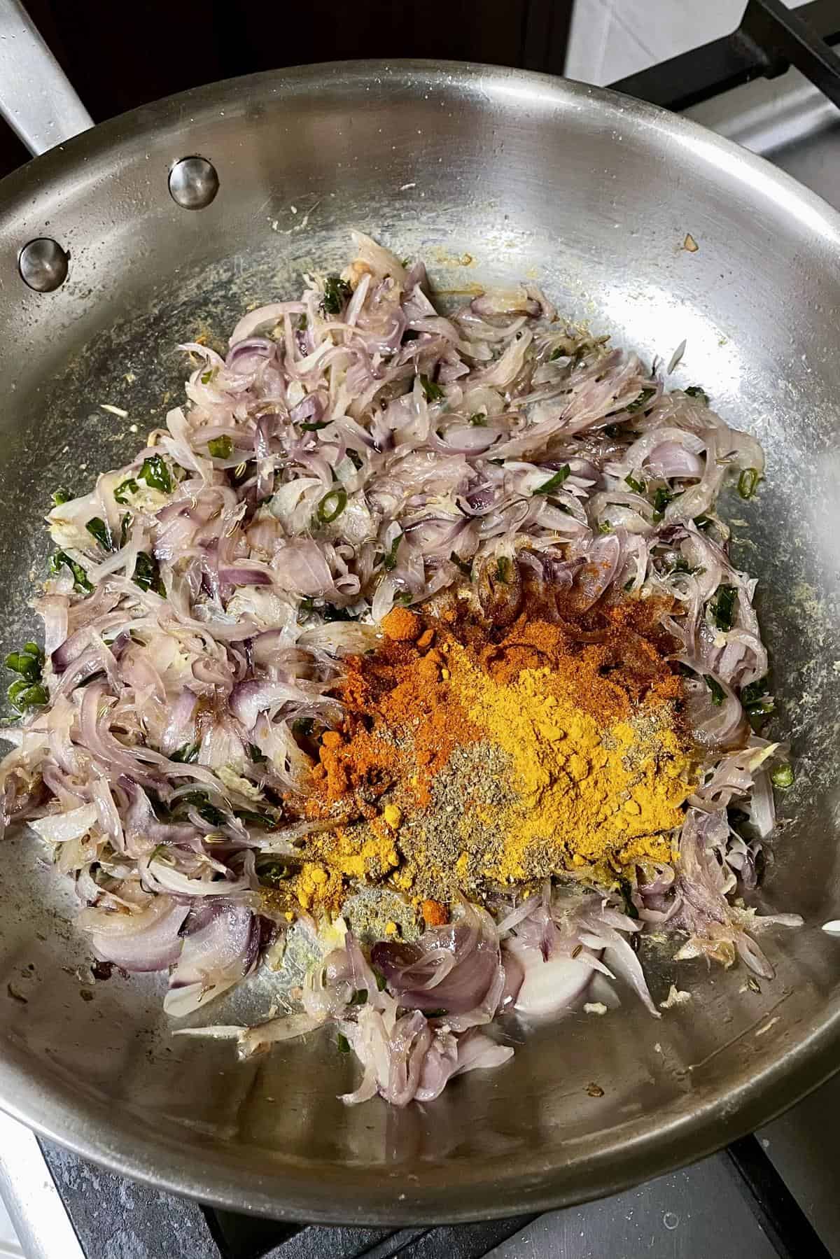 softened onions in pan with turmeric, chilli powder and ground pepper added for egg puff filling