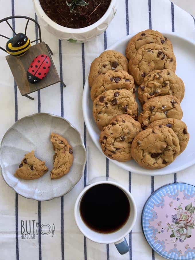 two black coffee with a plate of cookies