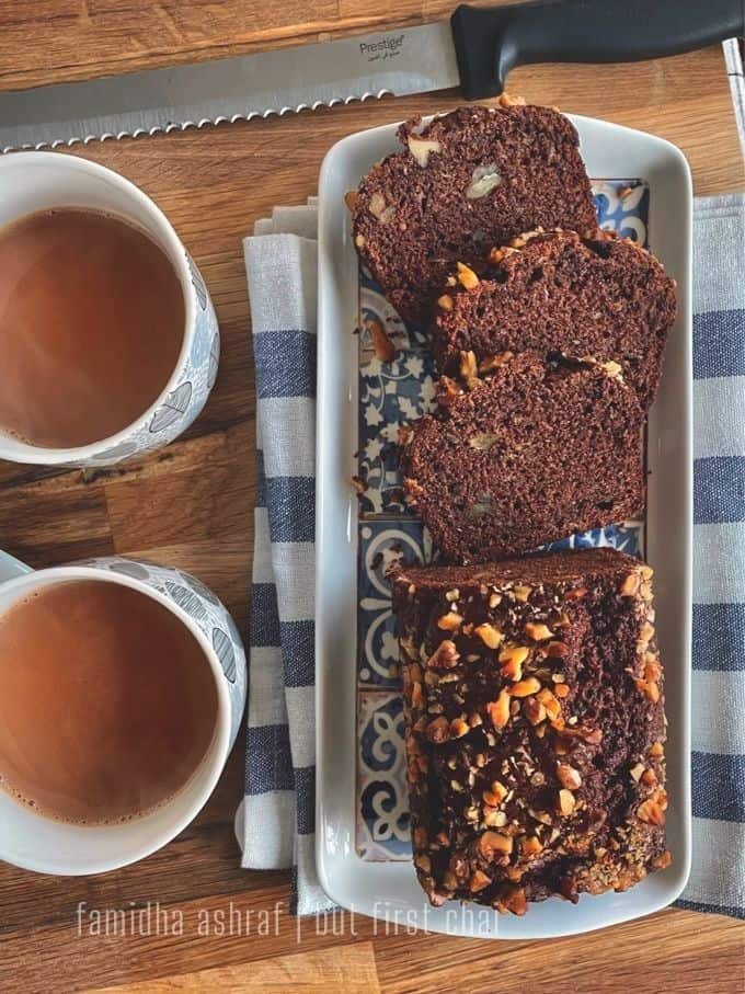 Chocolate Banana Walnut Bread sliced and served with two cups of chai
