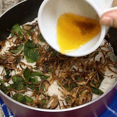 saffron brew being poured over the rice pot