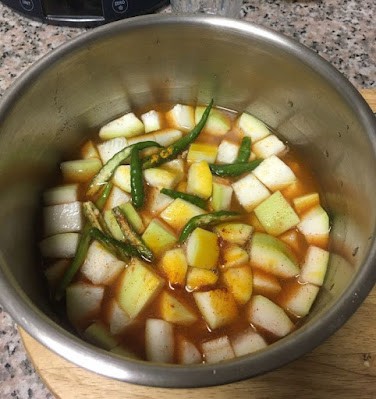 chopped bottle gourd with spices and water ready to cook