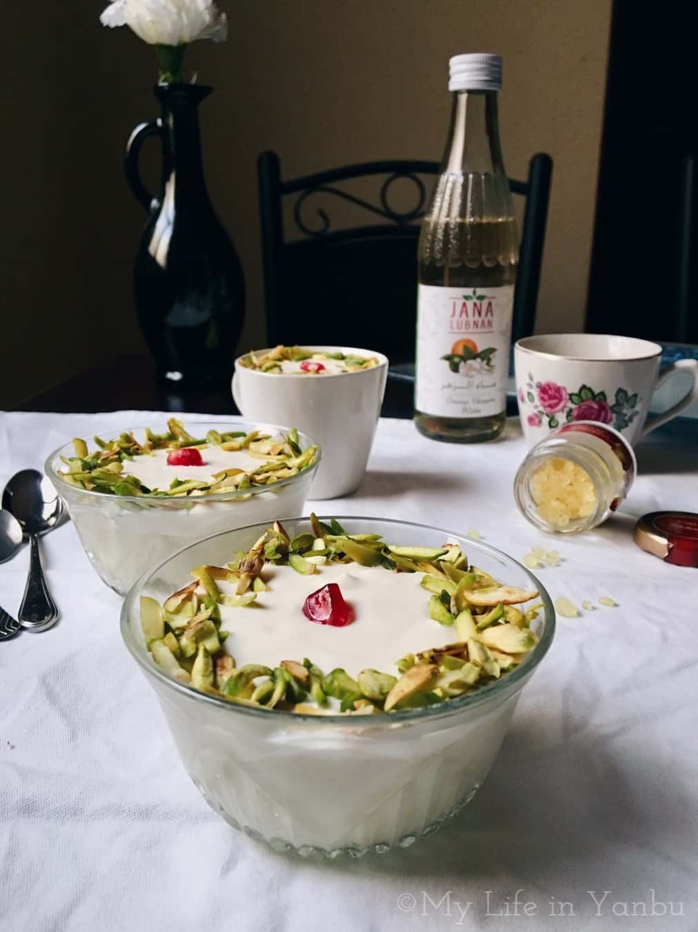 three bowls of lebanese nights served with a bottle of orange blossom water and mastic beads