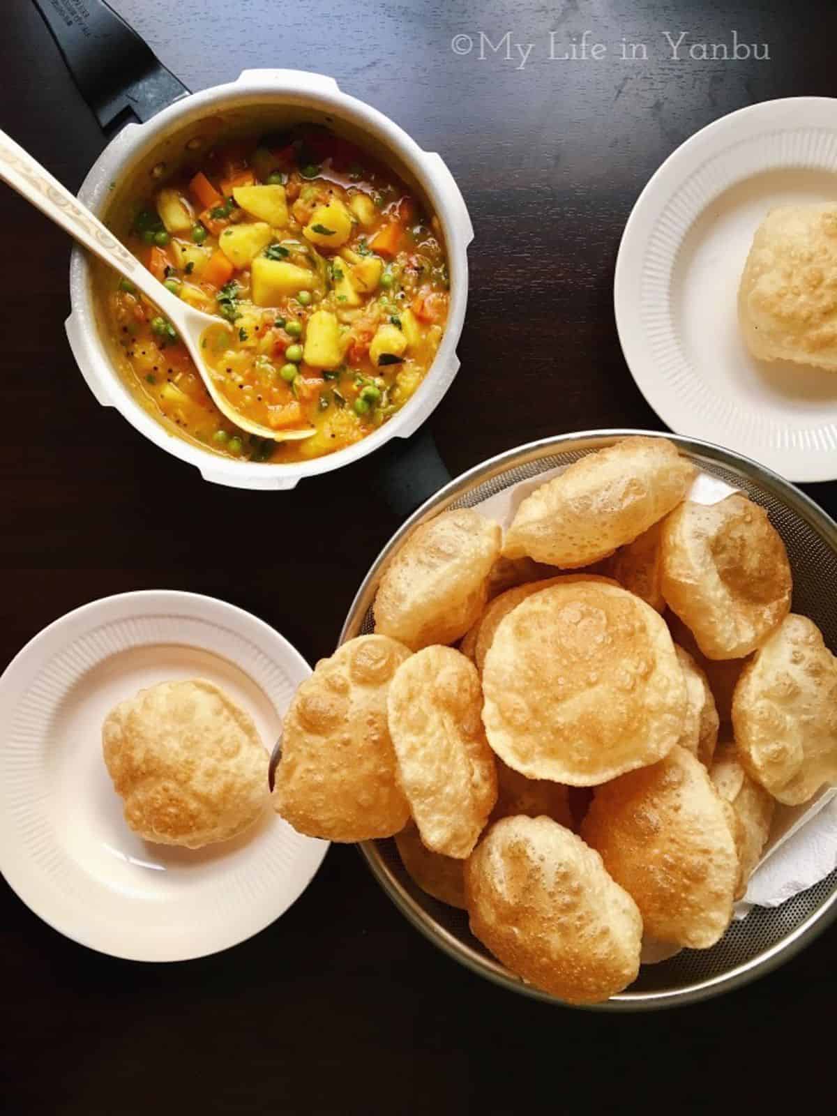 a basket of luchi bread served with aloo masala
