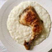 roasted whole chicken leg on a bed of creamy white rice
