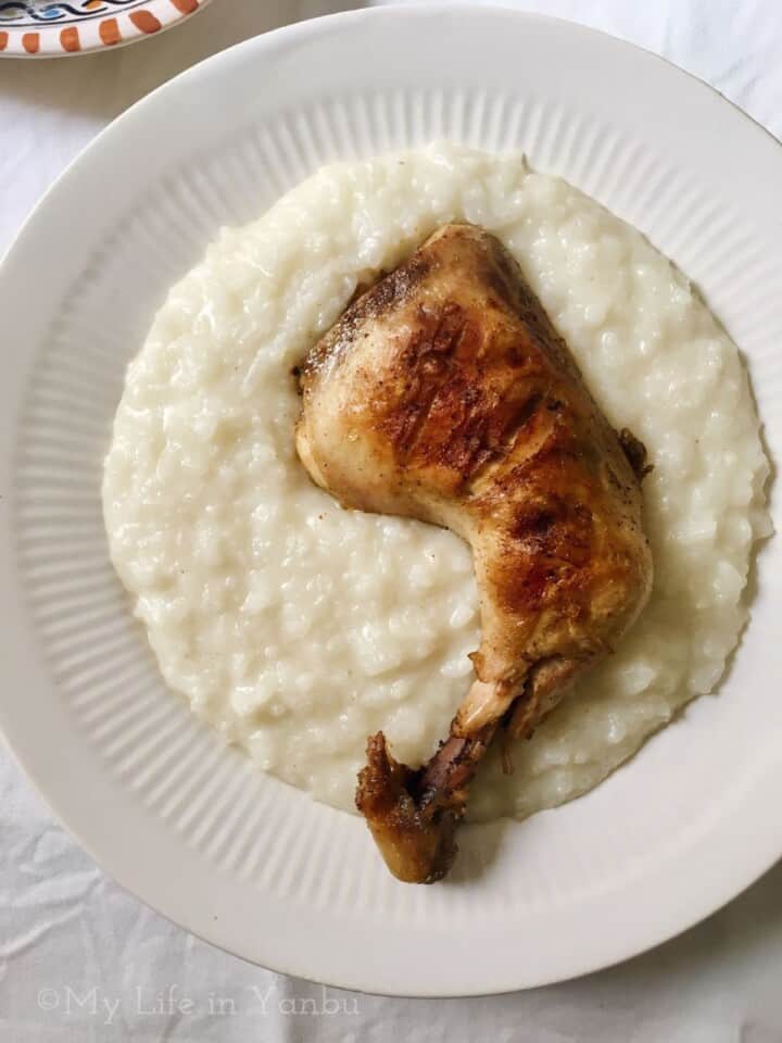 roasted whole chicken leg on a bed of creamy white rice
