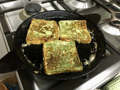 three bread slices being toasted on a pan