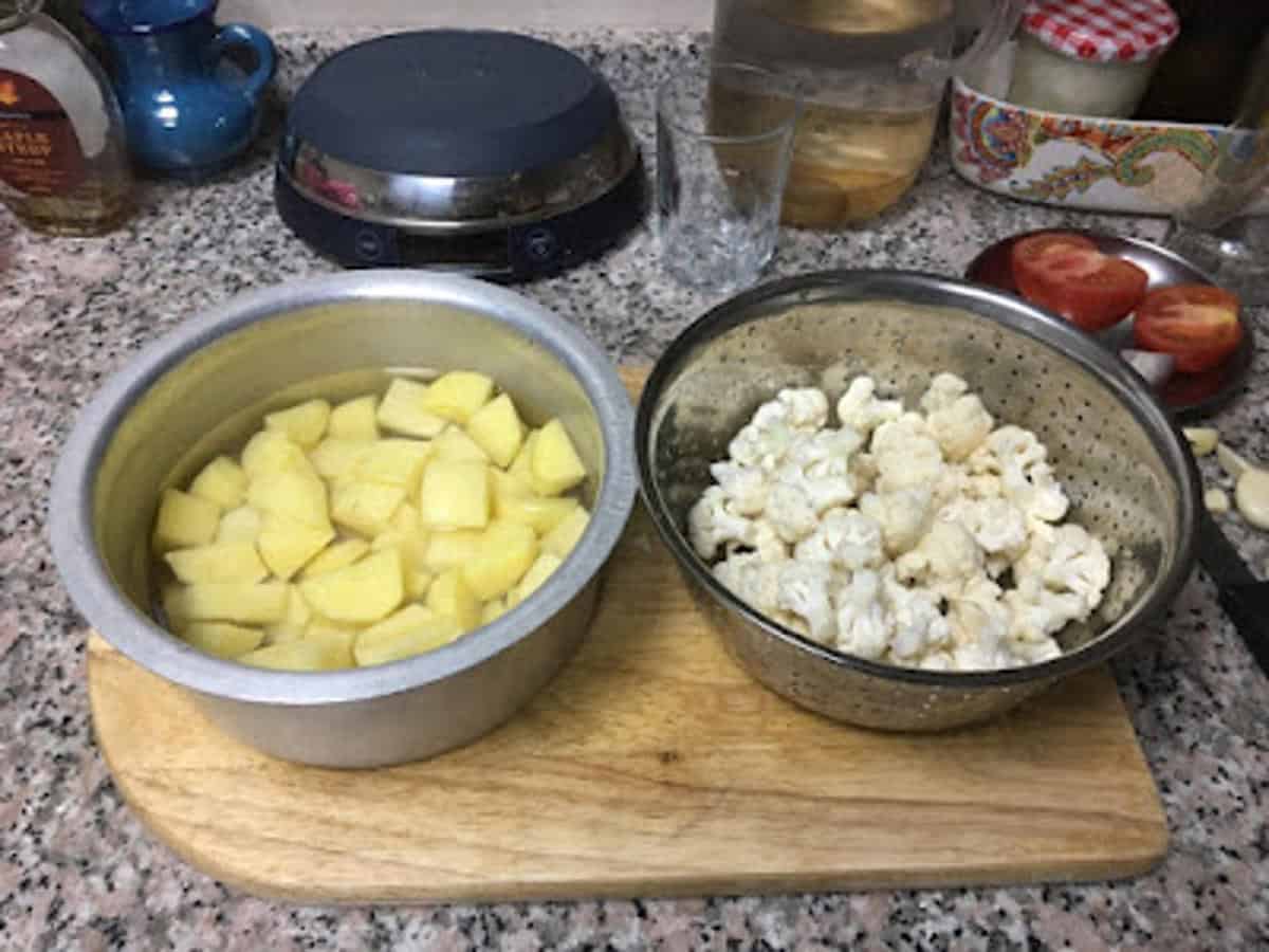 bowl of chopped potatoes and bowl of cauliflower florets