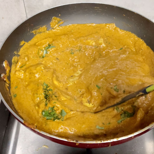 garnished with coriander leaves before serving the butter chicken