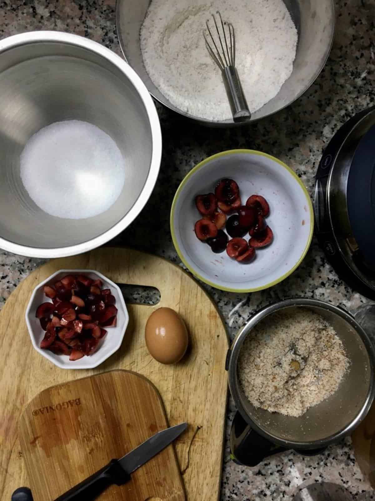 Fresh cherries and baking ingredients for cherry cake preparation.