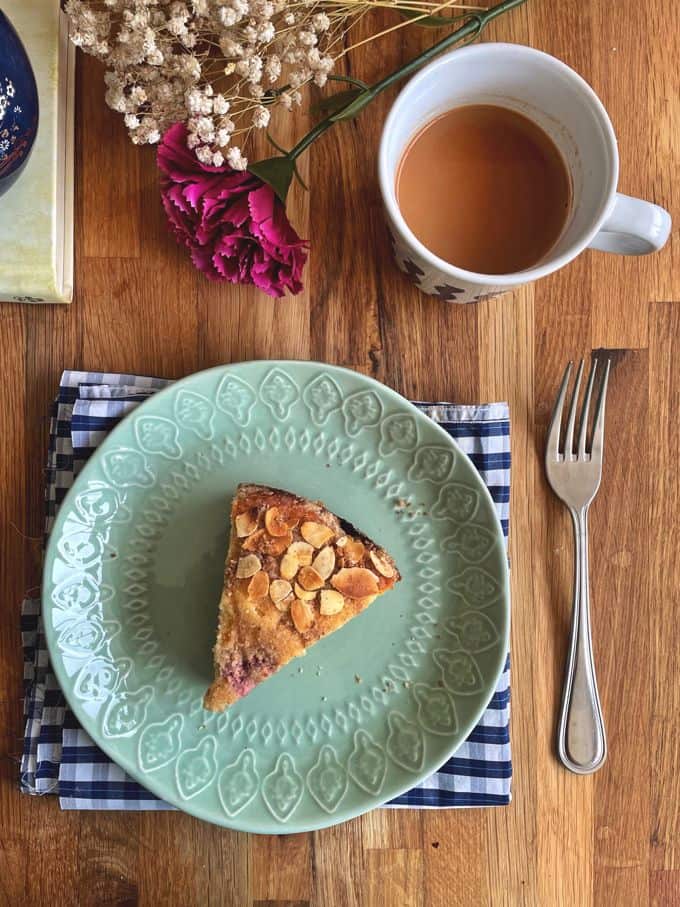 cherry cake piece with a cup of chai