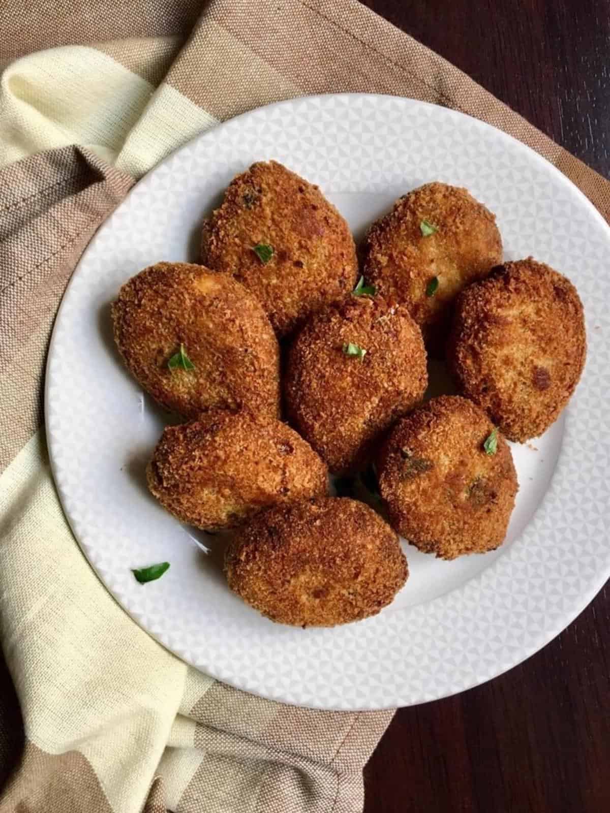 fried chicken cutlets on a white round plate