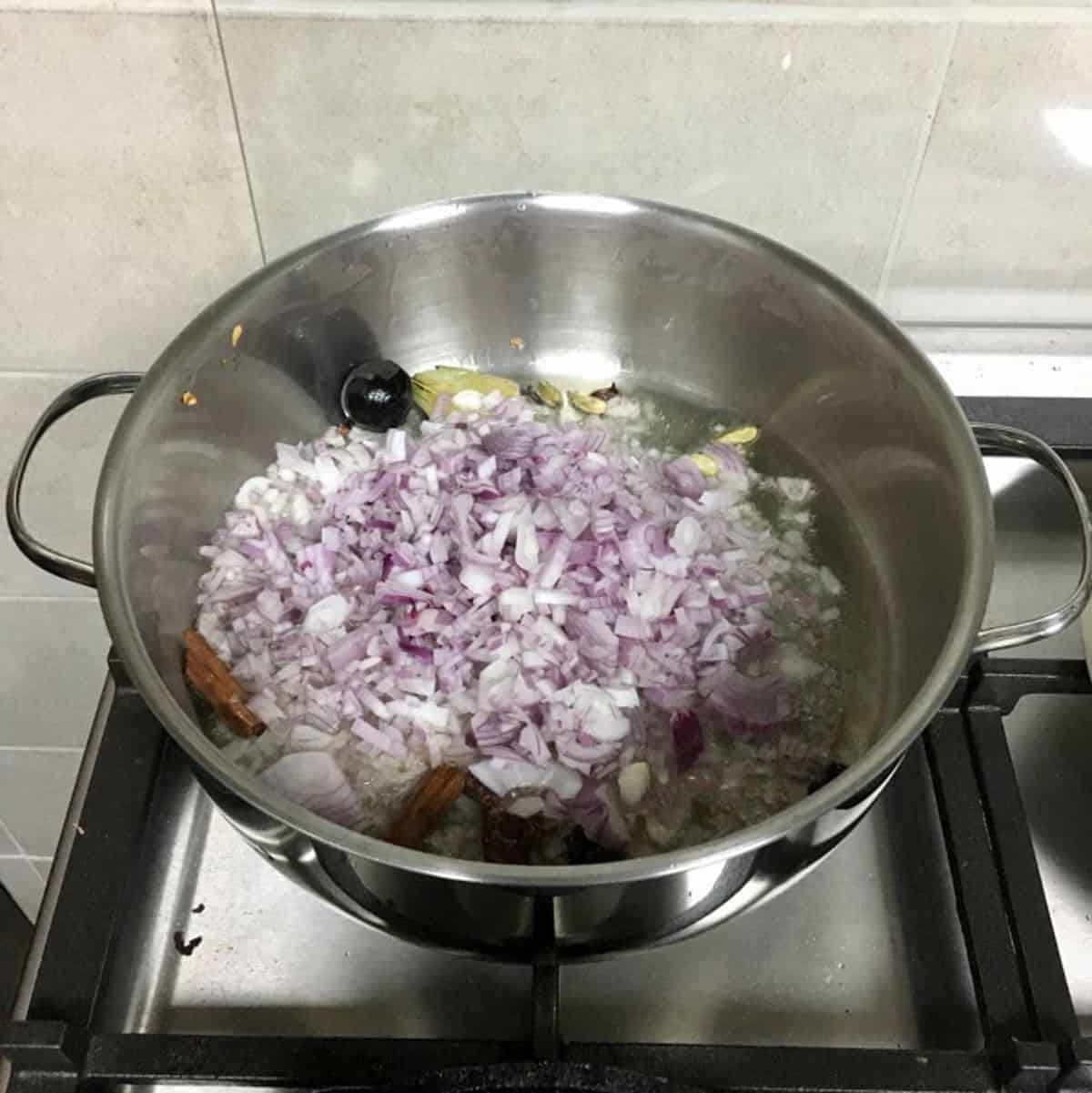 Finely chopped red onions in the pot.