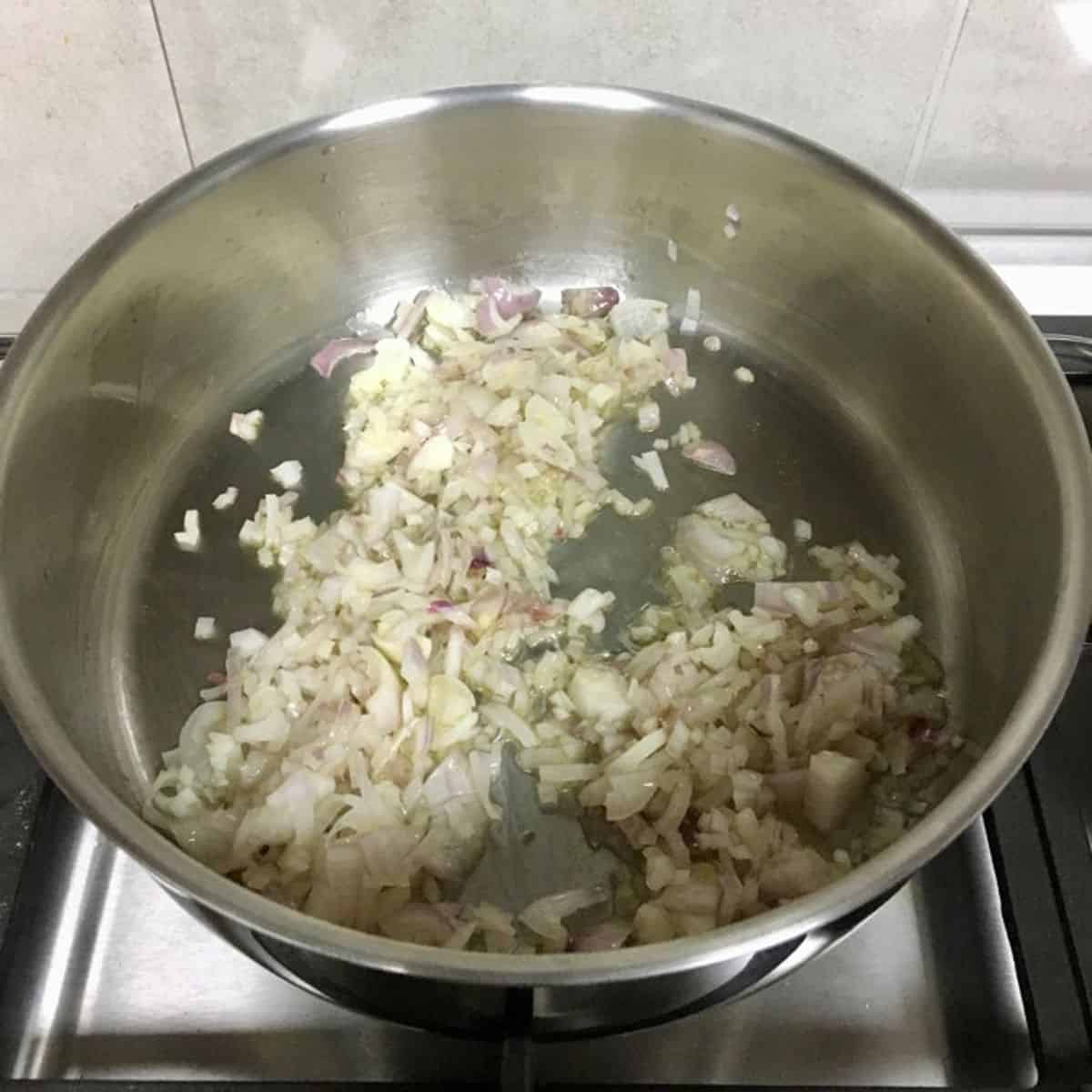 finely diced onions being sauted in oil. 