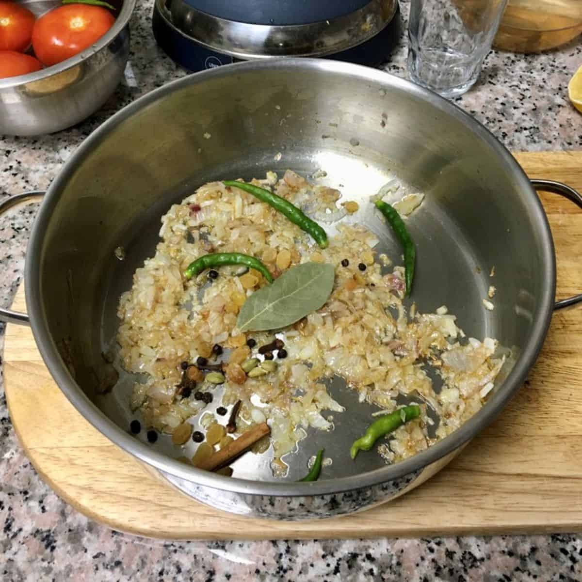 whole spices and green chillies in sauted onions