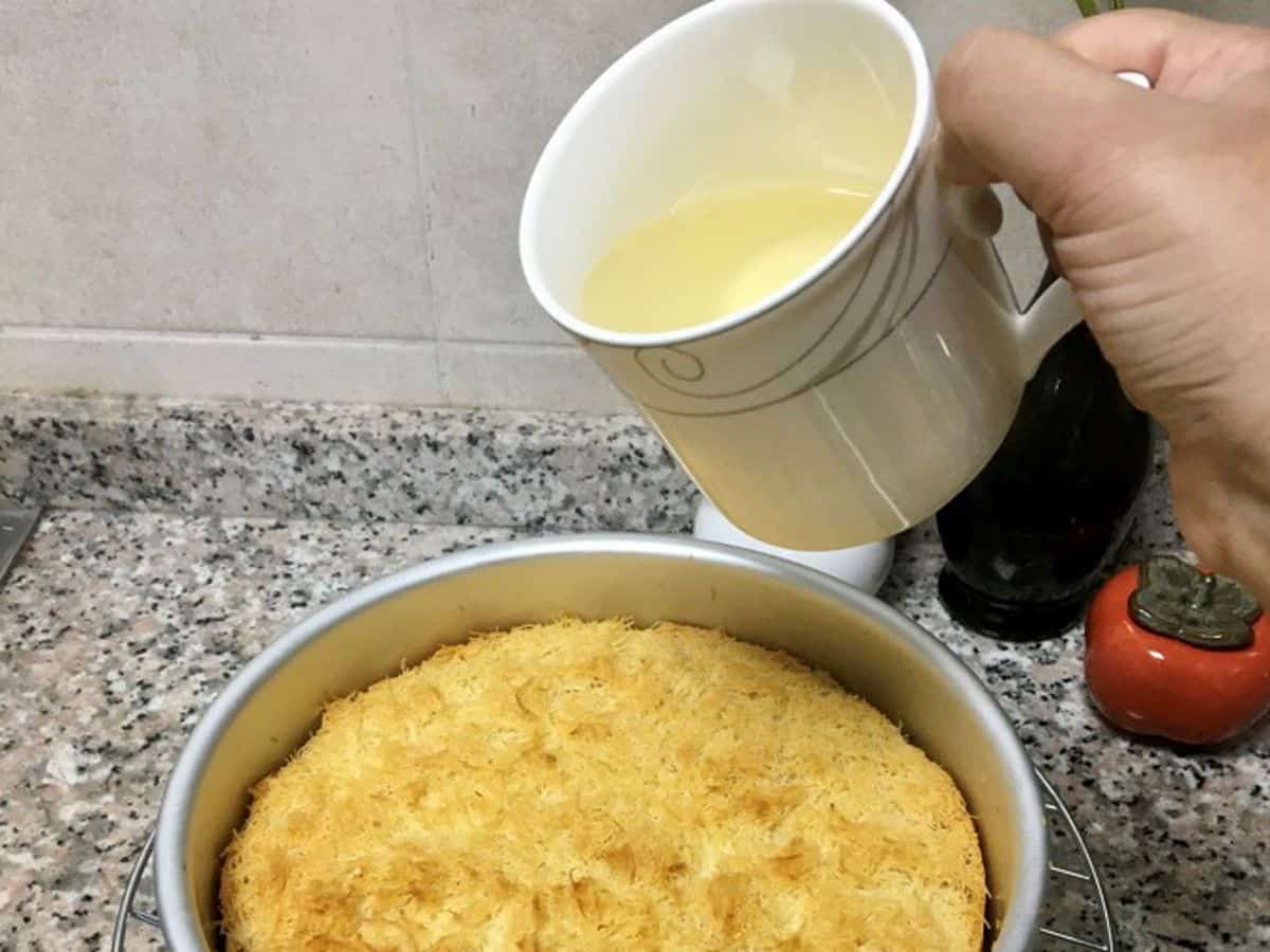 pouring cooled syrup over hot kunafa