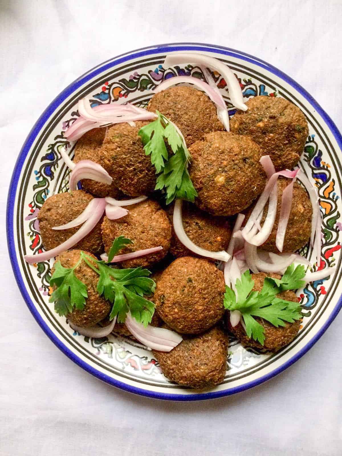 falafel served with onion slices and parsley garnish.