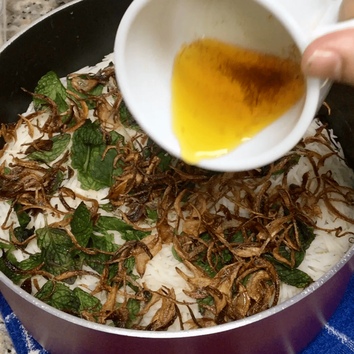 saffron brew being poured over the rice pot